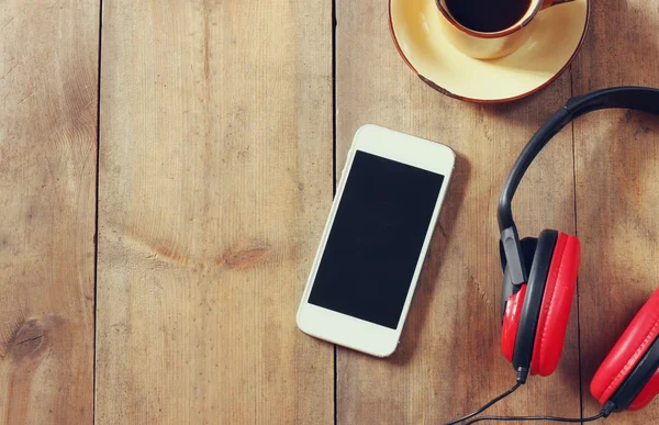 Vista dall'alto immagine di smartphone con cuffie a schermo bianco e tazza di caffè. spazio per il testo — Foto Stock