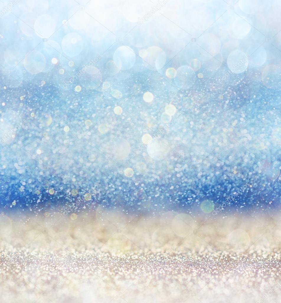 glitter vintage lights background with light burst . silver, blue and white. de-focused.