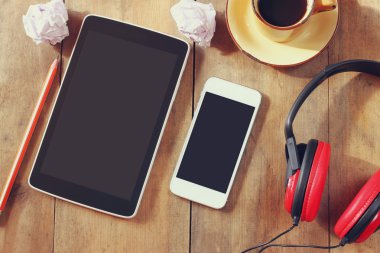 Üstten Görünüm görüntüsü tablet ve boş ekran, kulaklık ve kahve fincanı ahşap masa üzerinde sahip. metin için yer