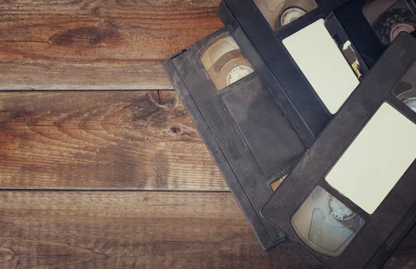 Pilha de fita de vídeo VHS cassete sobre fundo de madeira. foto vista superior — Fotografia de Stock