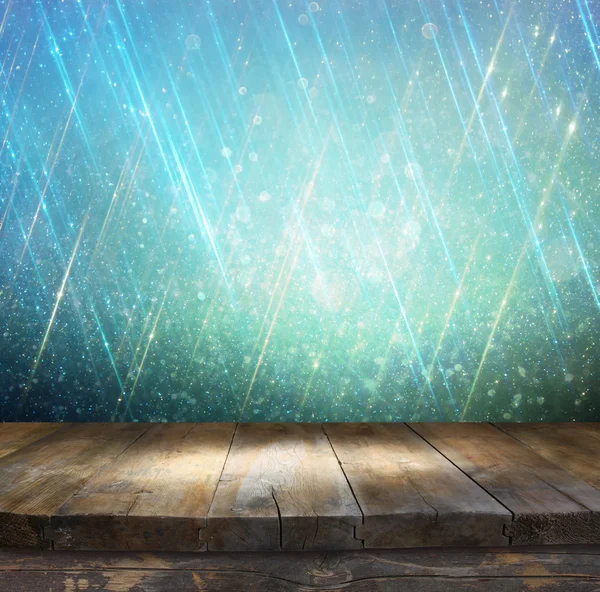 Rustic wood table in front of glitter silver, blue, and gold bokeh lights — Stock Photo, Image