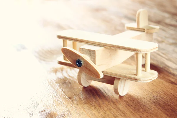 Drewniany samolot zabawka nad teksturowanej tło drewniane. obraz w stylu retro — Zdjęcie stockowe