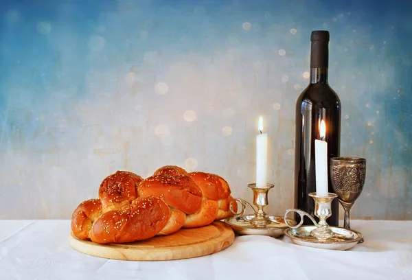 Shabbat image. challah bread, shabbat wine and candelas on wooden table. glitter overlay — Stock Photo, Image