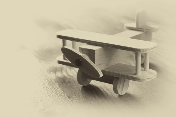 Wooden airplane toy over textured wooden background. retro style image.  black and white old style photo — Stock Photo, Image