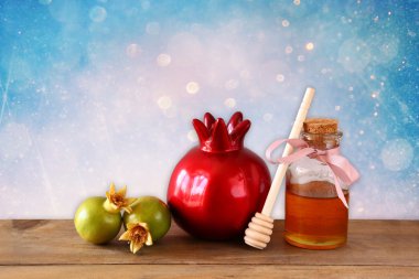 Rosh hashanah (jewesh tatil) kavramı - elma bal ve nar ahşap masa üzerinde. geleneksel tatil sembolleri.