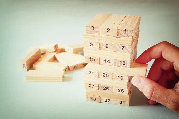 Mão masculina colocando bloco de madeira em uma torre. planeamento e conceito de estratégia — Fotografia de Stock