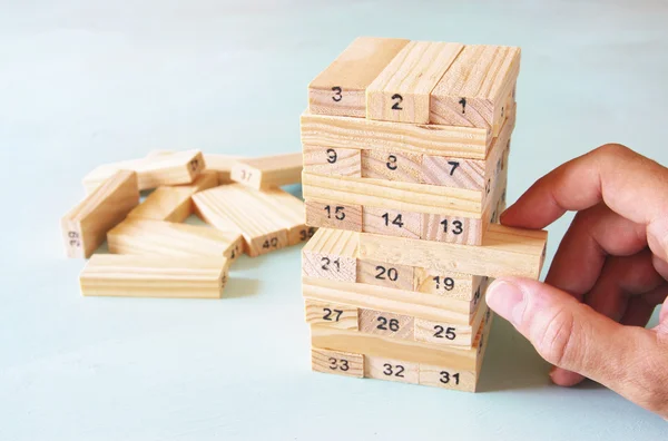 Mano masculina colocando bloque de madera en una torre. concepto de planificación y estrategia — Foto de Stock