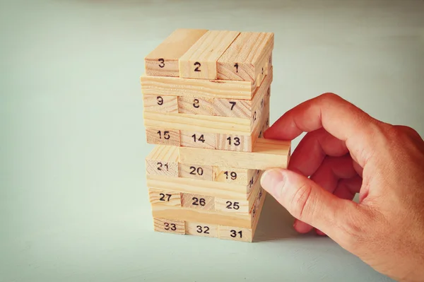 Männerhand legt Holzklötze auf einen Turm. Planung und Strategiekonzept — Stockfoto