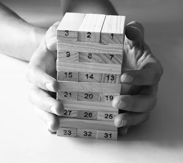 Αρσενική χέρι διάθεση ξύλινα μπλοκ σε έναν πύργο. πλάνισμα και στρατηγική έννοια — Φωτογραφία Αρχείου