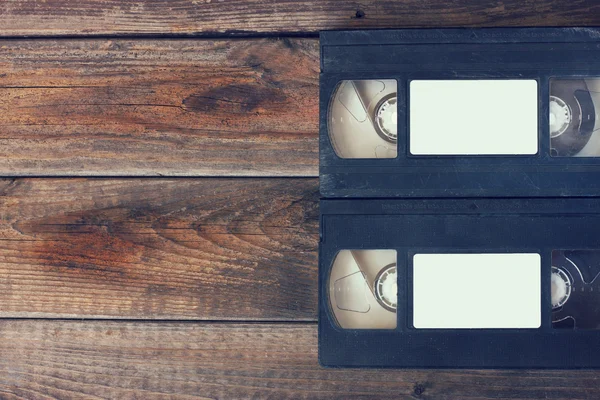 Tumpukan kaset pita video VHS di atas latar belakang kayu. foto pemandangan atas. gambar gaya retro — Stok Foto