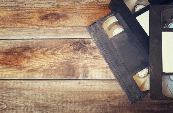 Pila di videocassetta VHS su sfondo di legno. foto vista dall'alto. immagine stile retrò — Foto Stock