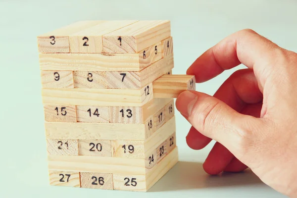 Männerhand legt Holzklötze auf einen Turm. Planung und Strategiekonzept — Stockfoto