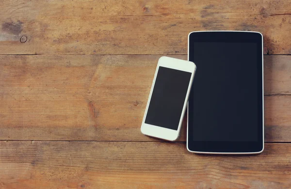 Top view image of smartphone and tablet device over wooden table room for text, ready for mockup. — Zdjęcie stockowe