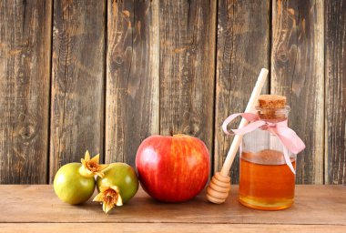 Rosh hashanah (jewesh tatil) kavramı - bal, elma ve nar ahşap masa üzerinde. geleneksel tatil sembolleri.