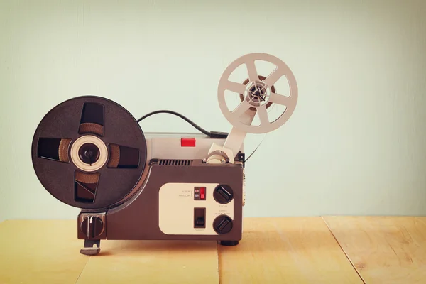 Projetor de filme velho de 8mm sobre mesa de madeira e fundo texturizado — Fotografia de Stock