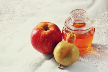 Rosh hashanah (jewesh tatil) kavramı - bal, elma ve nar ahşap masa üzerinde. geleneksel tatil sembolleri.