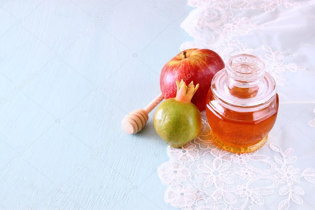 rosh hashanah (jewesh holiday) concept - honey, apple and pomegranate over wooden table. traditional holiday symbols.