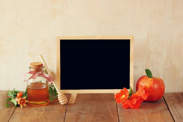 Rosh hashanah (jewesh holiday) concept - blackboard, honey and pomegranate over wooden table. traditional holiday symbols. — Stock Photo, Image