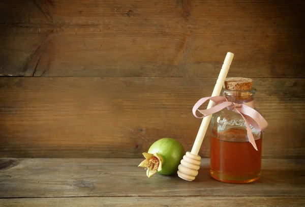 Rosh Hashana (jewesh semester) koncept - honung och granatäpple över träbord. traditionell semester symboler. — Stockfoto