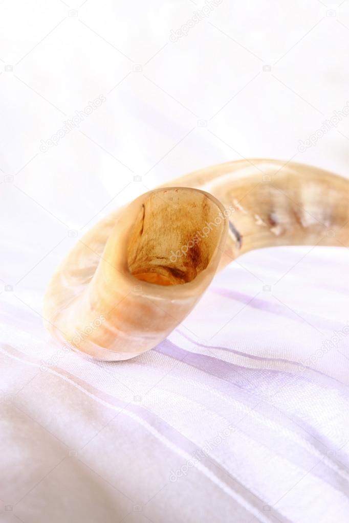 shofar (horn) on white prayer talit. room for text. rosh hashanah (jewish holiday) concept . traditional holiday symbol.