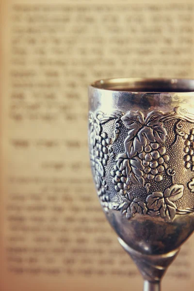 Vintage shabbath silver cup of wine in front of torah prayer book — ストック写真