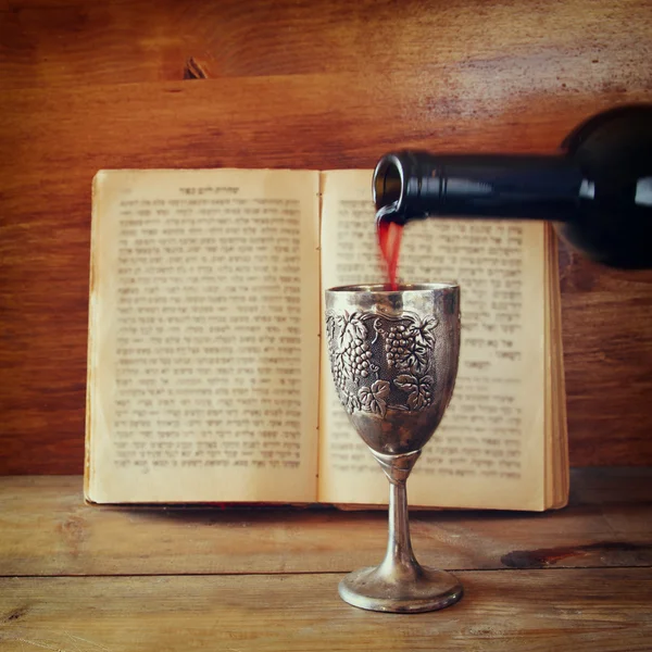 Vintage shabbath silver cup of wine in front of torah prayer book — Stockfoto