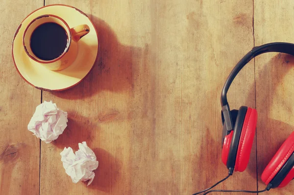 Image of headphones over wooden table and empty crumpled paper. top view. retro filter — Stock Photo, Image