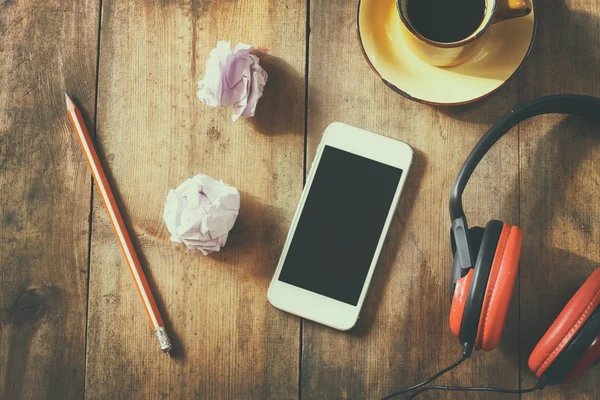 Top view image of smartphone with blank screen headphones and coffee cup. room for text . faded style image — Stockfoto