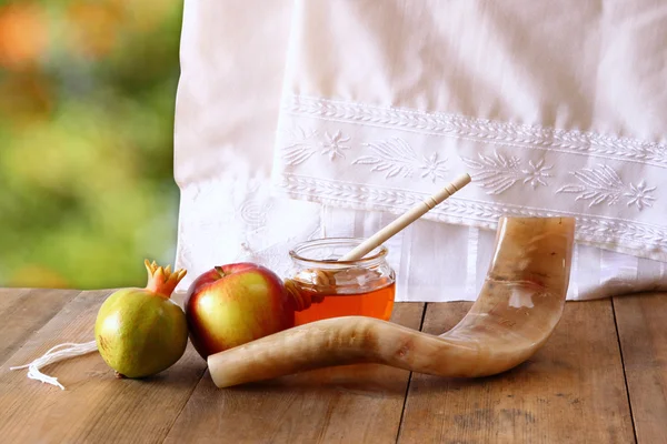 Rosh hashanah (jewesh holiday) concept - shofar, torah book, honey, apple and pomegranate over wooden table. traditional holiday symbols. — Stok fotoğraf