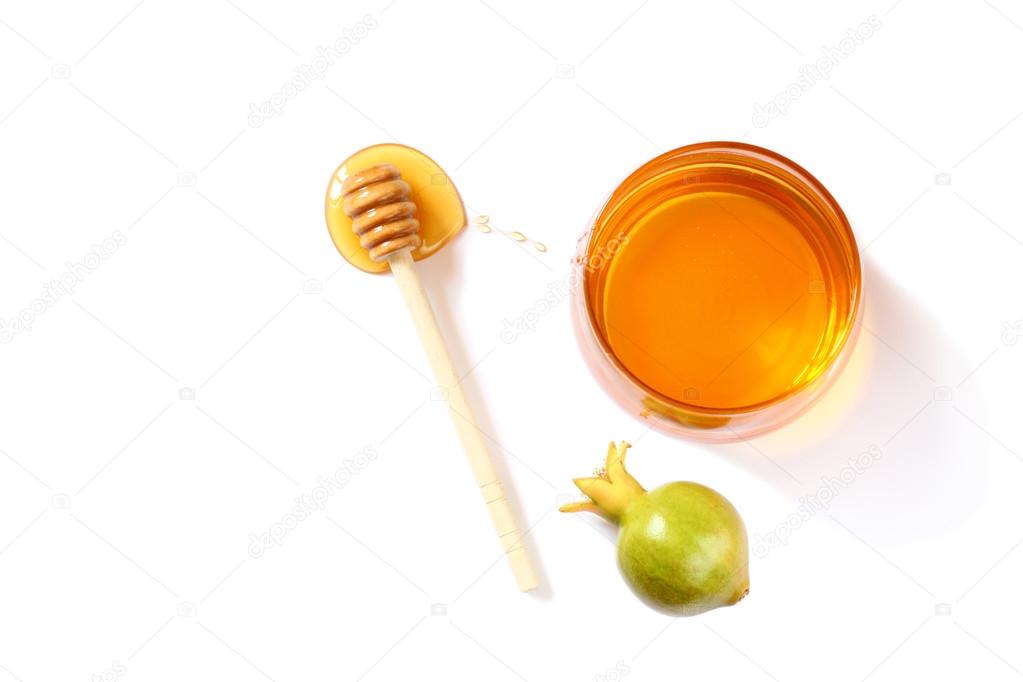 rosh hashanah (jewesh holiday) concept - honey and pomegranate isolated on white. traditional holiday symbols.