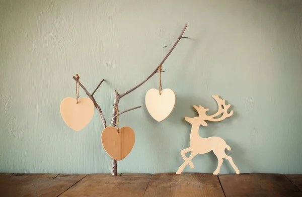 Pendaison coeurs en bois sur et décoration en bois de cerf de pluie sur fond en bois — Photo