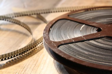 top view image of old 8 mm movie reel over wooden background clipart