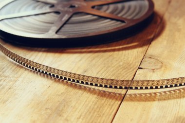 top view image of old 8 mm movie reel over wooden background clipart