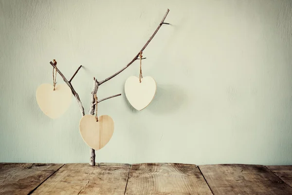 Abstract image of hanging wooden hearts over wooden background — Stock Photo, Image