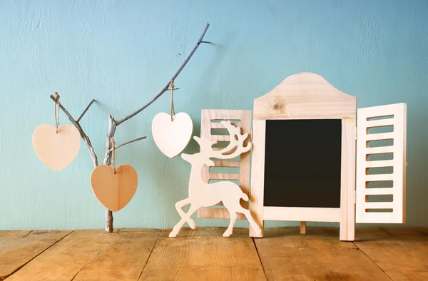 Rámeček dekorativní tabuli a dřevěné závěsné srdce dřevěný stůl. Připraveno pro text nebo maketa. retro filtrovaného obrazu — Stock fotografie
