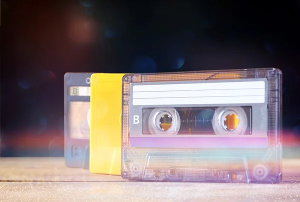 Impilare nastri cassette sopra tavolo di legno. retrò filtrato con sovrapposizione glitter — Foto Stock