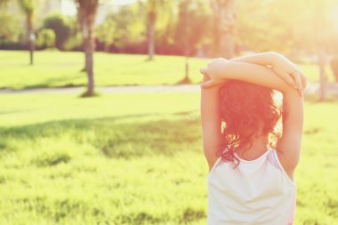 abstract photo of back side of happy kid looking at the sunset in forest, explore and adventure concept