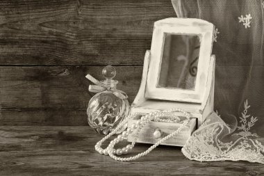 Vintage inci, ayna ve parfüm şişesi üzerinde ahşap masa ile antika ahşap takı kutusu. siyah ve beyaz tarzı fotoğraf