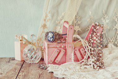 Vintage jewelelry, antika ahşap takı kutusu ve parfüm şişesi üzerinde ahşap masa. Filtre uygulanmış görüntü