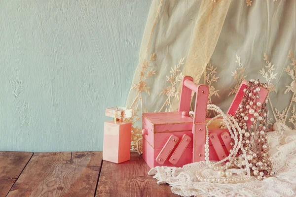 Jóias vintage, caixa de jóias de madeira antiga e garrafa de perfume na mesa de madeira. imagem filtrada — Fotografia de Stock