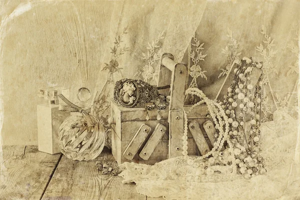Vintage-Schmuck, antike Holzschmuckschatulle und Parfümflasche auf Holztisch. gefiltertes Bild, Schwarz-Weiß-Foto alten Stils — Stockfoto