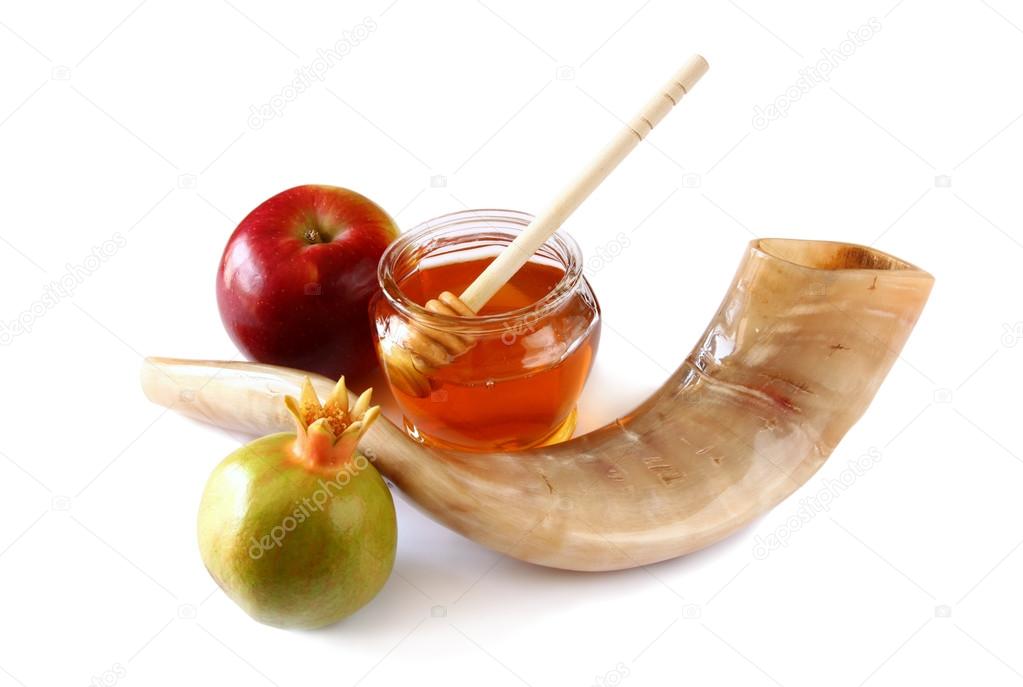 rosh hashanah (jewesh holiday) concept - shofar (horn), honey, apple and pomegranate isolated on white. traditional holiday symbols.