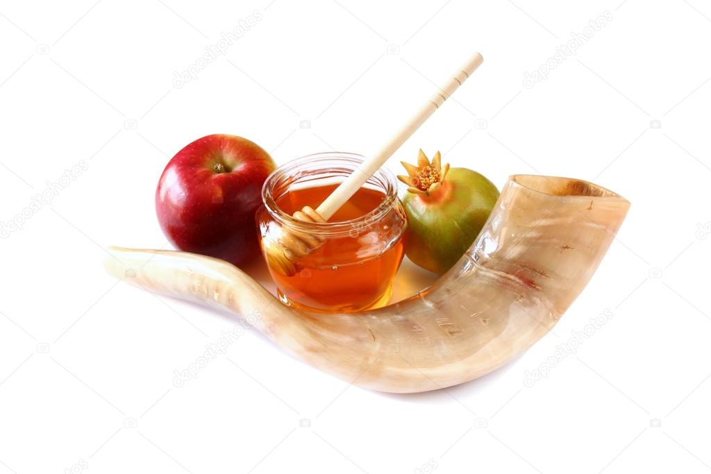 rosh hashanah (jewesh holiday) concept - shofar (horn), honey, apple and pomegranate isolated on white. traditional holiday symbols.