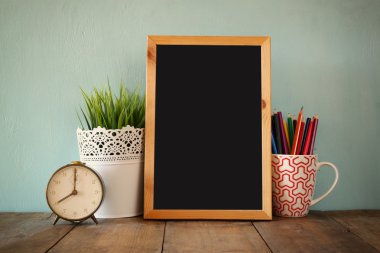 Blackboard, colorful pencils and clock.