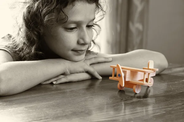 Enfant regardant un avion en bois . — Photo