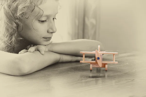 Niño mirando avión de madera . — Foto de Stock