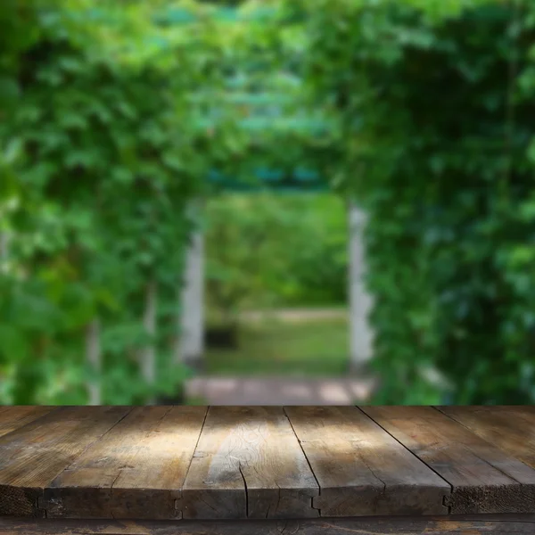 Vintage wooden board table in front of dreamy and abstract park landscape — Stock Photo, Image