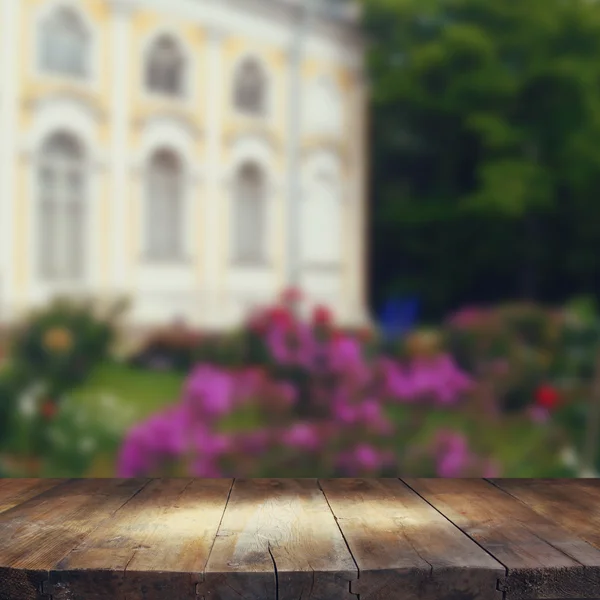 Vintage wooden board table in front of rustic counrty garden landscape — Stock Photo, Image