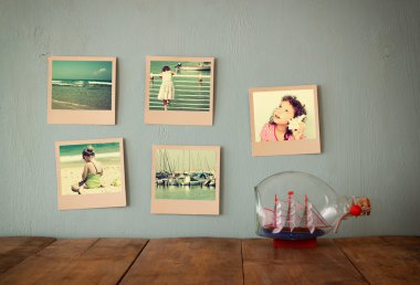 yanında şişe dekoratif tekne ahşap dokulu arka plan üzerinde anlık fotoğraf asmak. Retro filtre uygulanmış görüntü