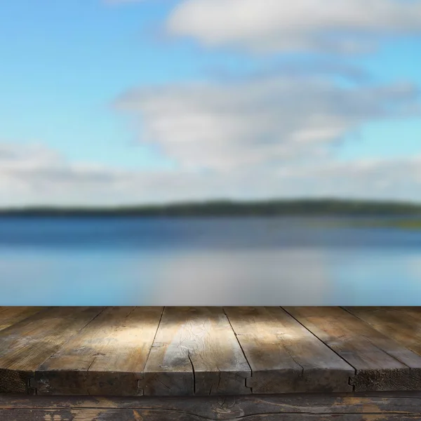 Mesa de madera vintage frente al paisaje del lago bosque de ensueño y abstracto con destello de lente . — Foto de Stock